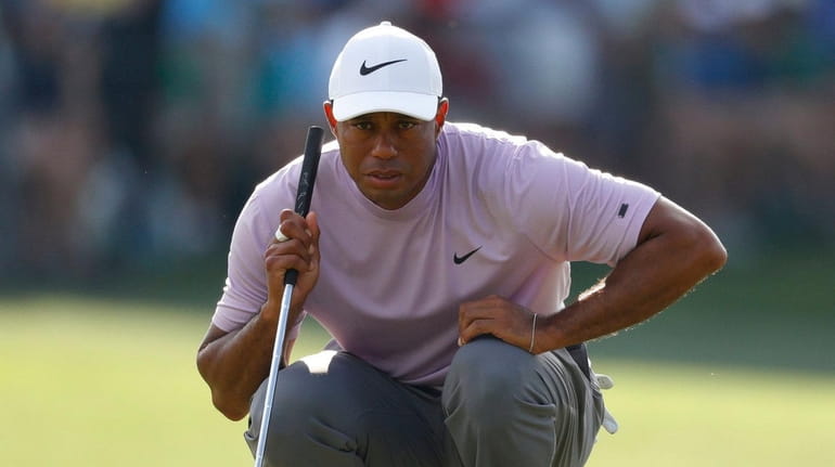 Tiger Woods lines up his putt on the 17th hole during...