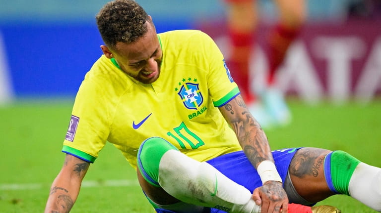 Brazil's Neymar grabs his ankle after an injury during the...