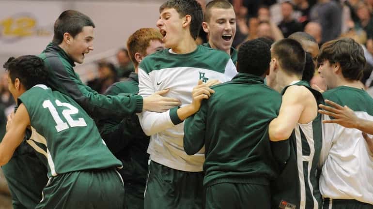 Holy Trinity teammates celebrate after their 57-55 win over St....