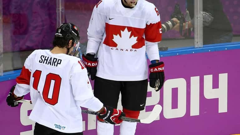 Patrick Sharp and Rick Nash of Canada watch as a...