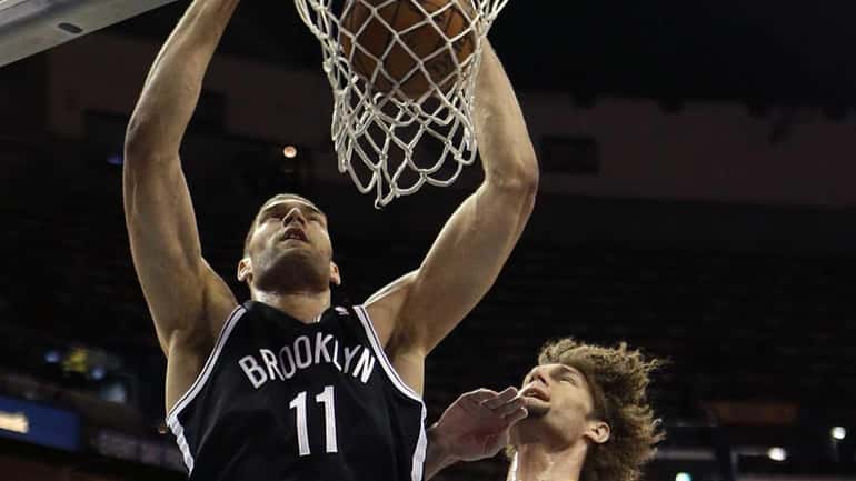 Nets center Brook Lopez slam dunks over his twin brother,...