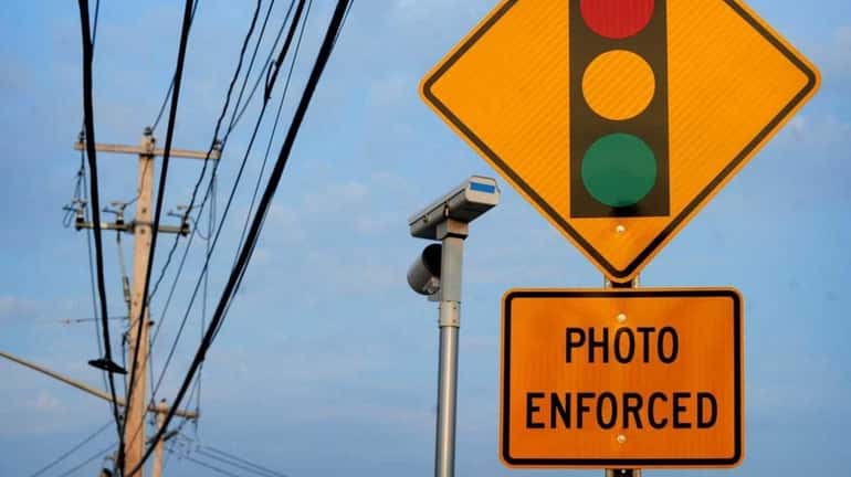A sign and red-light camera are pictured on Middle Country...