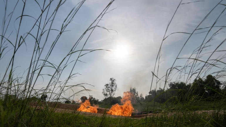 A burning flare is visible at an oil extraction area...