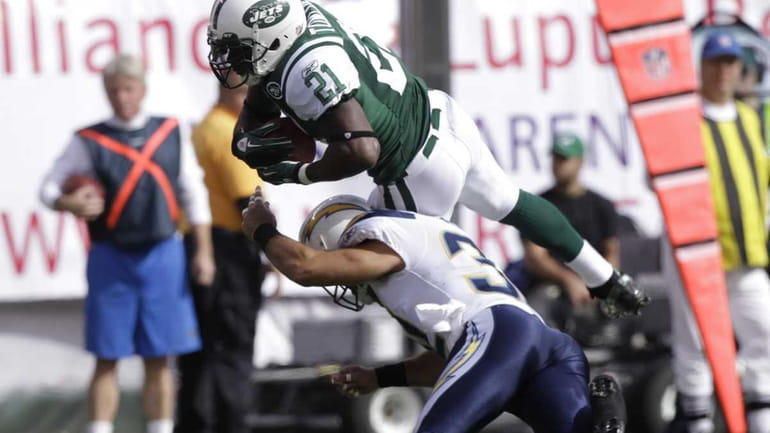 New York Jets' LaDainian Tomlinson, top, jumps with the ball...