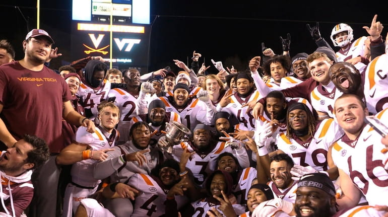 Virginia Tech players pose for a photograph after a win...