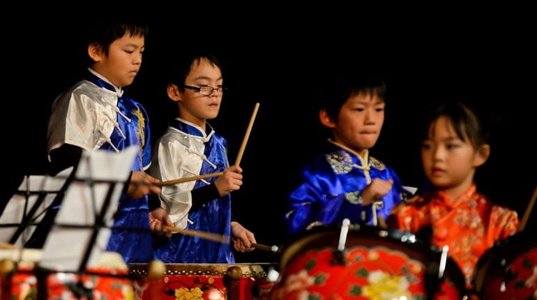 Members of the New York Chinese Drum School perform onstage...