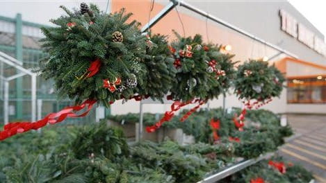 Christmas wreaths blow in the wind outside a Home Depot...