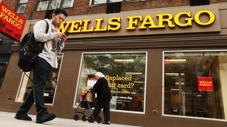 People walk by a Wells Fargo bank branch on October...