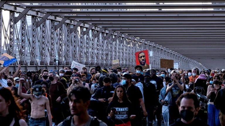 Activists march on the Brooklyn Bridge in New York Tuesday,...