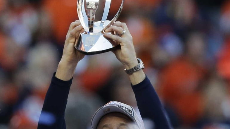 Denver Broncos head coach John Fox celebrates with the trophy...