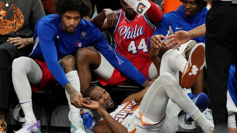 Phoenix Suns forward Kevin Durant falls into the Philadelphia 76ers...