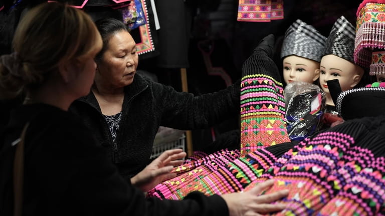 Shoppers look for pleated skirts and other clothing for Hmong...