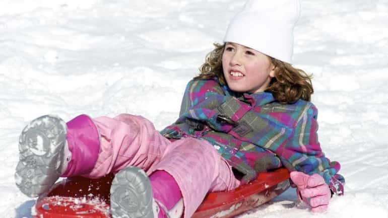 This little girl barely waits for her sled to stop...