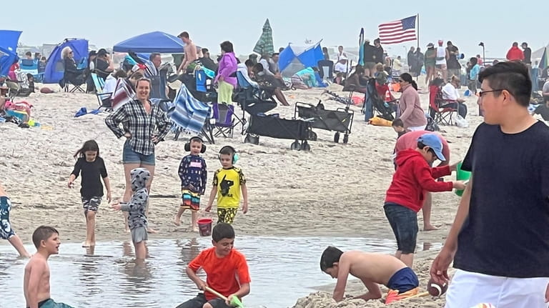 Kids keep themselves occupied with summerlike beach activities before Saturday's...