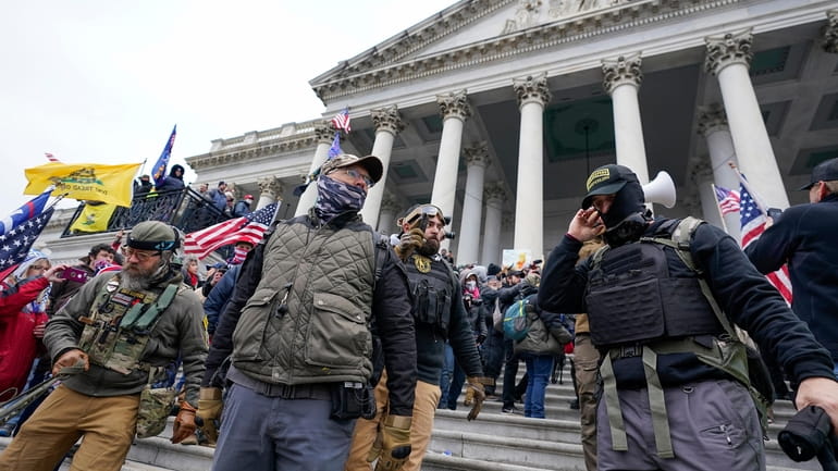 Members of the Oath Keepers extremist group stand on the...