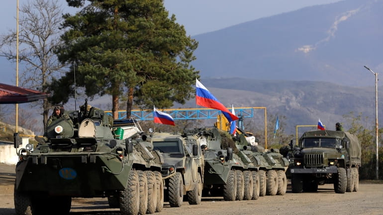 Russian peacekeepers' vehicles are parked at a checkpoint on the...