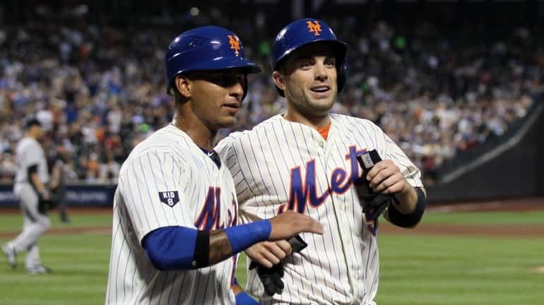 David Wright, right, and Ronny Cedeno celebrate after scoring in...