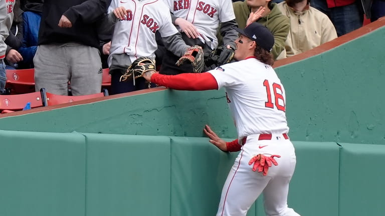 Boston Red Sox's Jarren Duran (16) leaps to the stands...