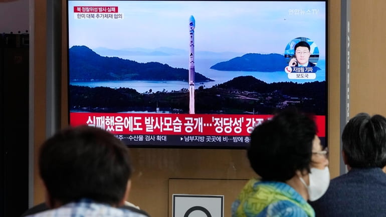 A TV screen shows an image of North Korea's rocket...
