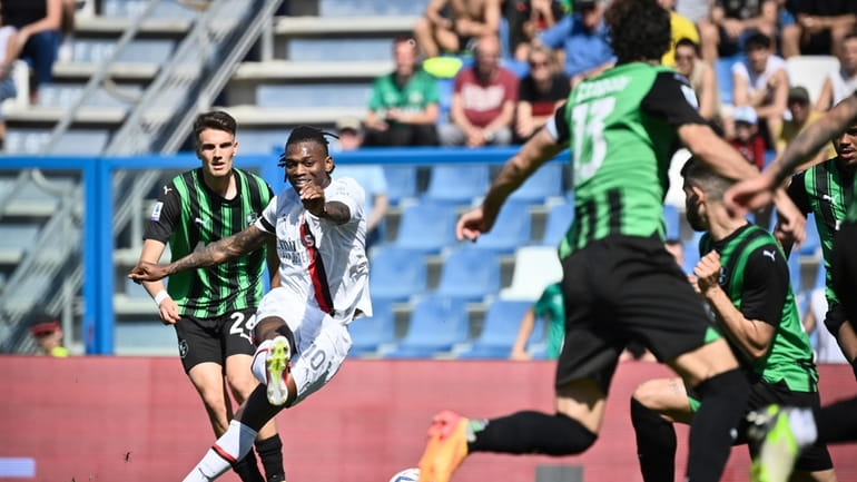 Milan's Rafael Leao, second left, scores their side's first goal...