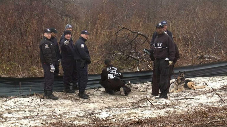 State Police and other investigators examine an object on the...