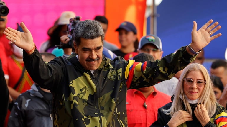 President Nicolas Maduro, accompanied by first lady Cilia Flores, greets...