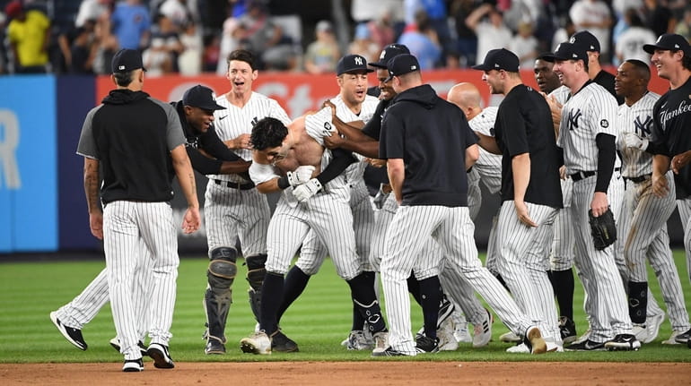 The Yankees' Ryan LaMarre is mobbed by teammates after he...