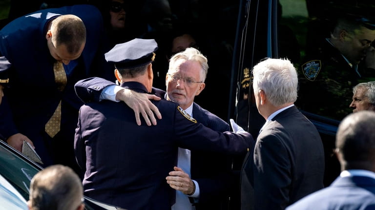 The father of slain NYPD Officer Brian Mulkeen, center, is...