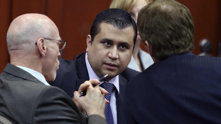 George Zimmerman, center, talks to his attorneys Don West, left,...