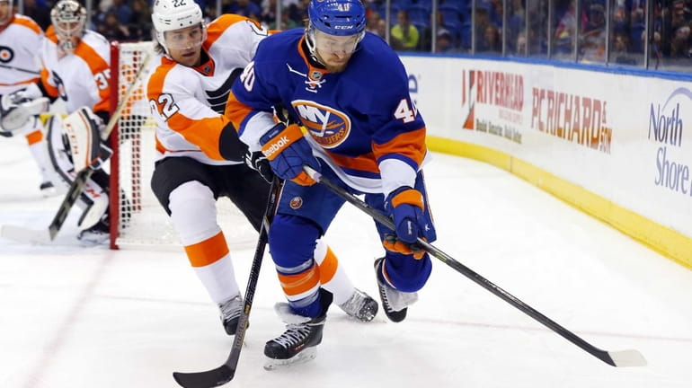 Michael Grabner of the Islanders tries to control the puck...