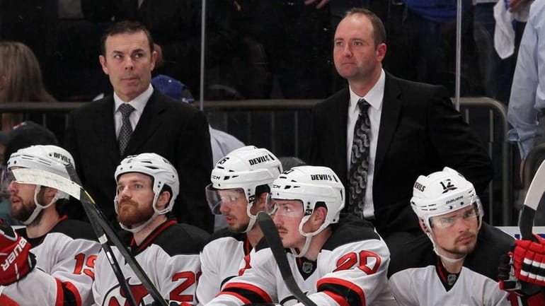 Devils head coach Peter DeBoer, right, looks on against the...