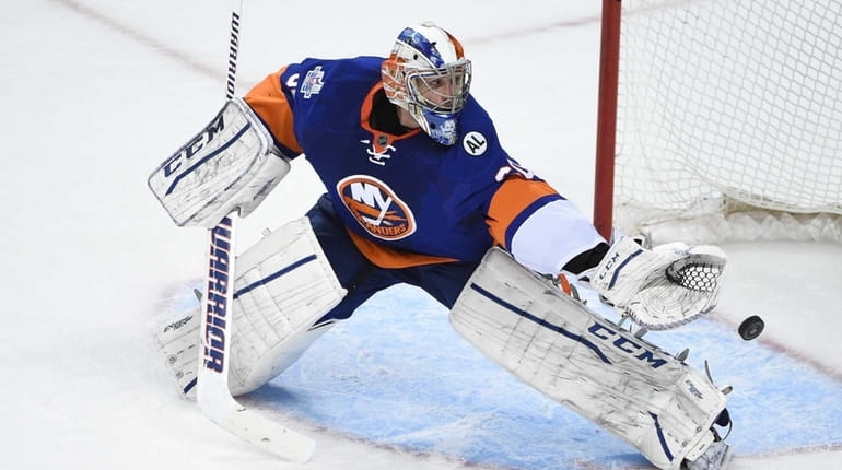 New York Islanders goalie Kevin Poulin makes a save against...