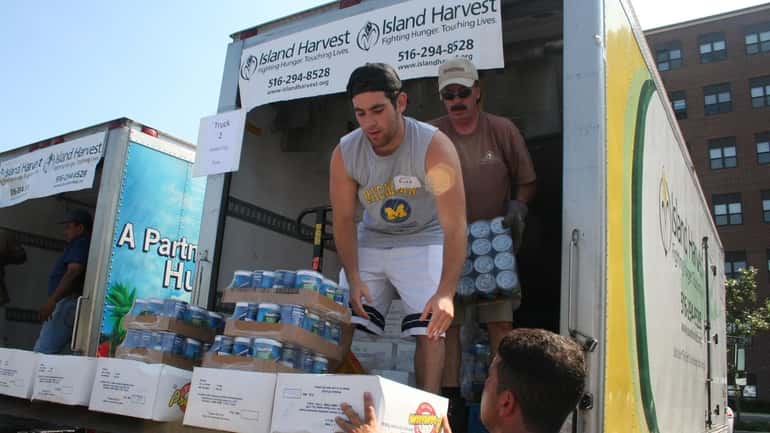 Island Harvest volunteers unloading donated food for distribution among LI’s...
