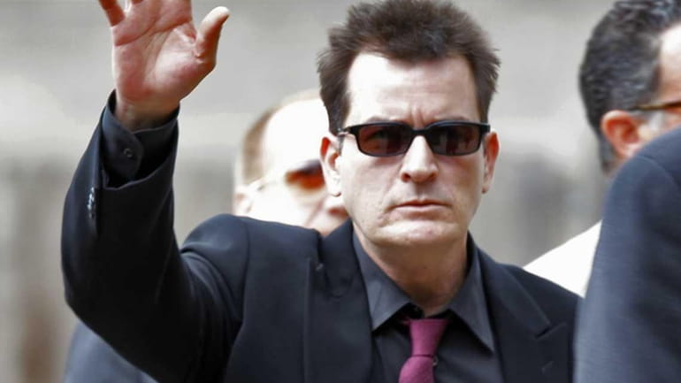 Charlie Sheen waves as he arrives at the Pitkin County...