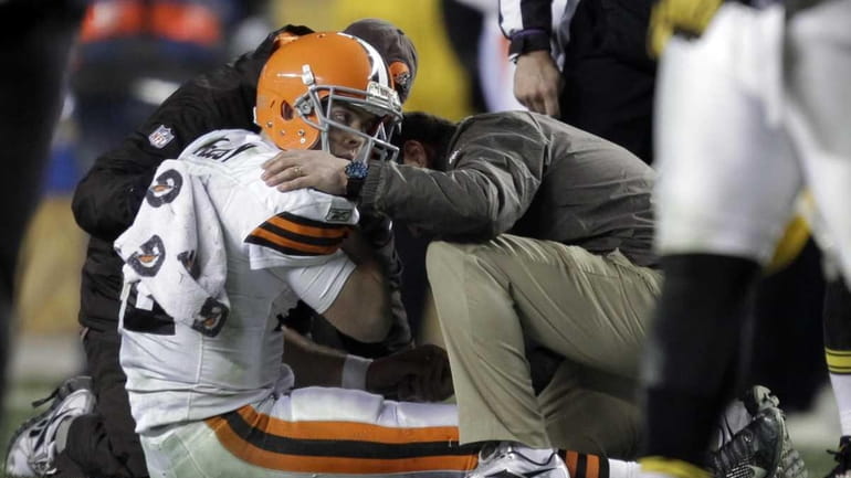 Trainers tend to Cleveland Browns quarterback Colt McCoy after he...