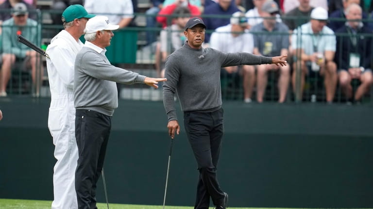 Tiger Woods, right, talks with Fred Couples on the fourth...