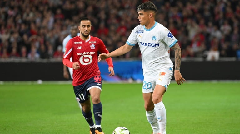 Marseille's Joaquin Correa, right, challenges for the ball with Lille's...