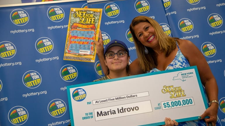 New York Lottery's Yolanda Vega presents a winning check to...
