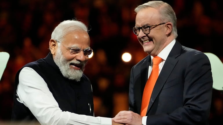 Indian Prime Minister Narendra Modi, left, shakes hands with Australian...