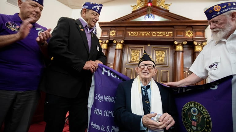 Eli Soblick, 98, is presented with a Purple Heart flag...