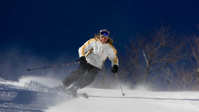 A woman skis down the groomed slope at Hunter Mountain...