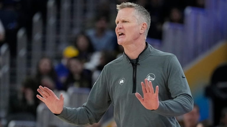 Golden State Warriors head coach Steve Kerr gestures toward players...