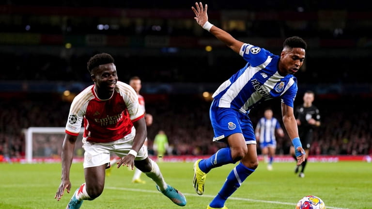 Porto's Wendell, right, and Arsenal's Bukayo Saka battle for the...