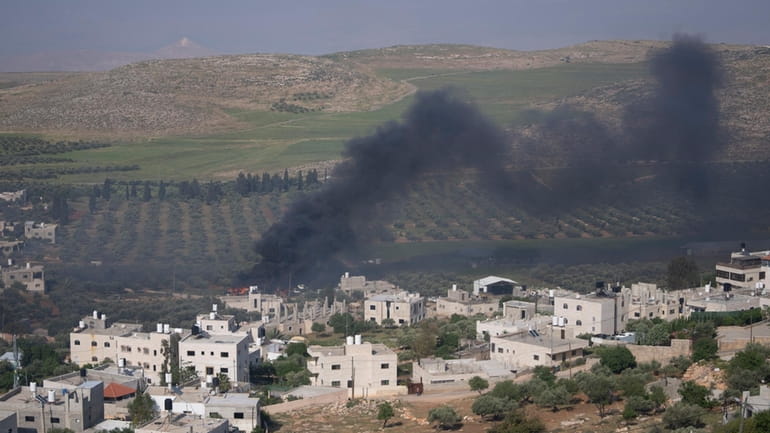 Smoke fills the sky after Israeli settlers set fire to...
