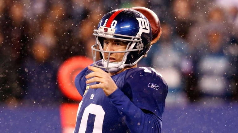Eli Manning of the New York Giants looks to pass...
