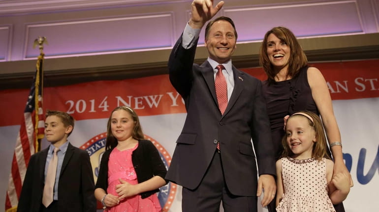 Republican gubernatorial nominee Rob Astorino stands on stage with his...