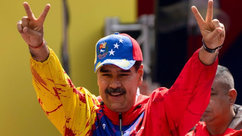 President Nicolas Maduro flashes victory signs during an event commemorating...