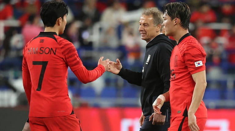 South Korea's head coach Jurgen Klinsmann, second from right, encourages...