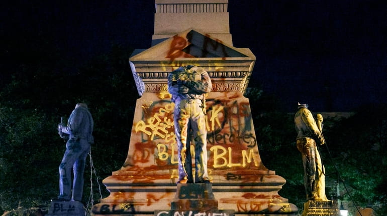 The statues on the Confederate monument are covered in graffiti...