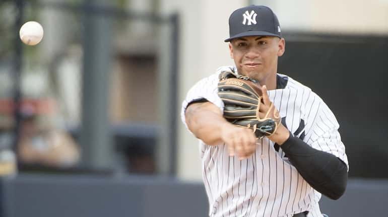 New York Yankees' SS Gleyber Torres fielding a ball hit...